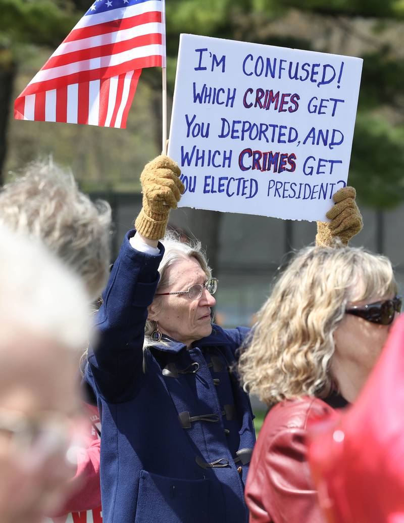 A protester listens to speakers Saturday, May 3, 2025, at Hopkins Park in DeKalb during a May Day Rally for Democracy to protest against Trump administration policies.
