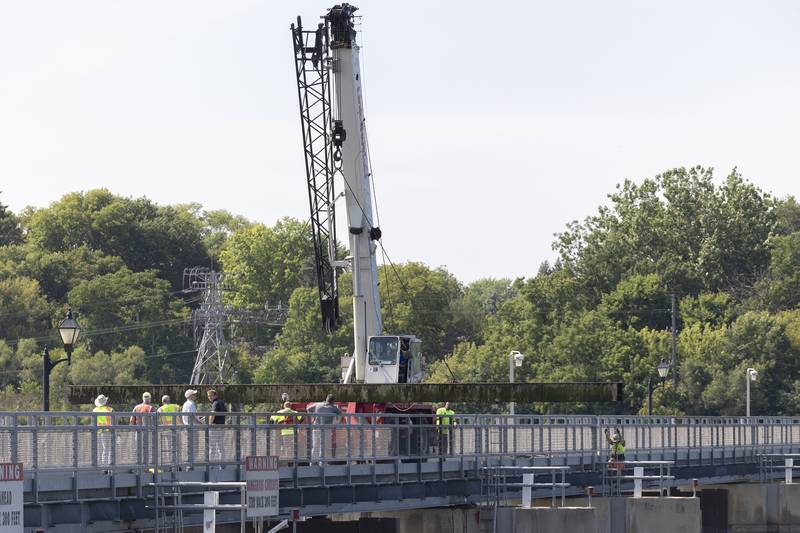IDNR workers move stop logs from one side of the upper dam to the other to perform maintenance on gates Wednesday, July 19, 2023.