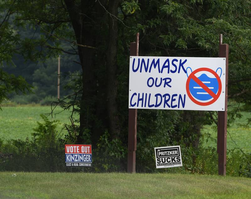 A homemade "Unmask Our Children" signs stands in a residential lawn alongside Illinois Route 2 in Lee County. Some parents in area school districts have asked local school boards not to require children to wear masks when the school year starts.