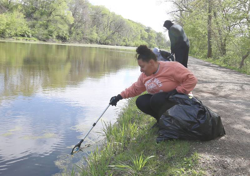 Tiffany Gottberg collects a piece of trash during the Perfectly Flawed Foundation cleanup on Saturday, April 26, 2025 near the Lock 14 shelter on the Illinois & Michigan Canal in La Salle.