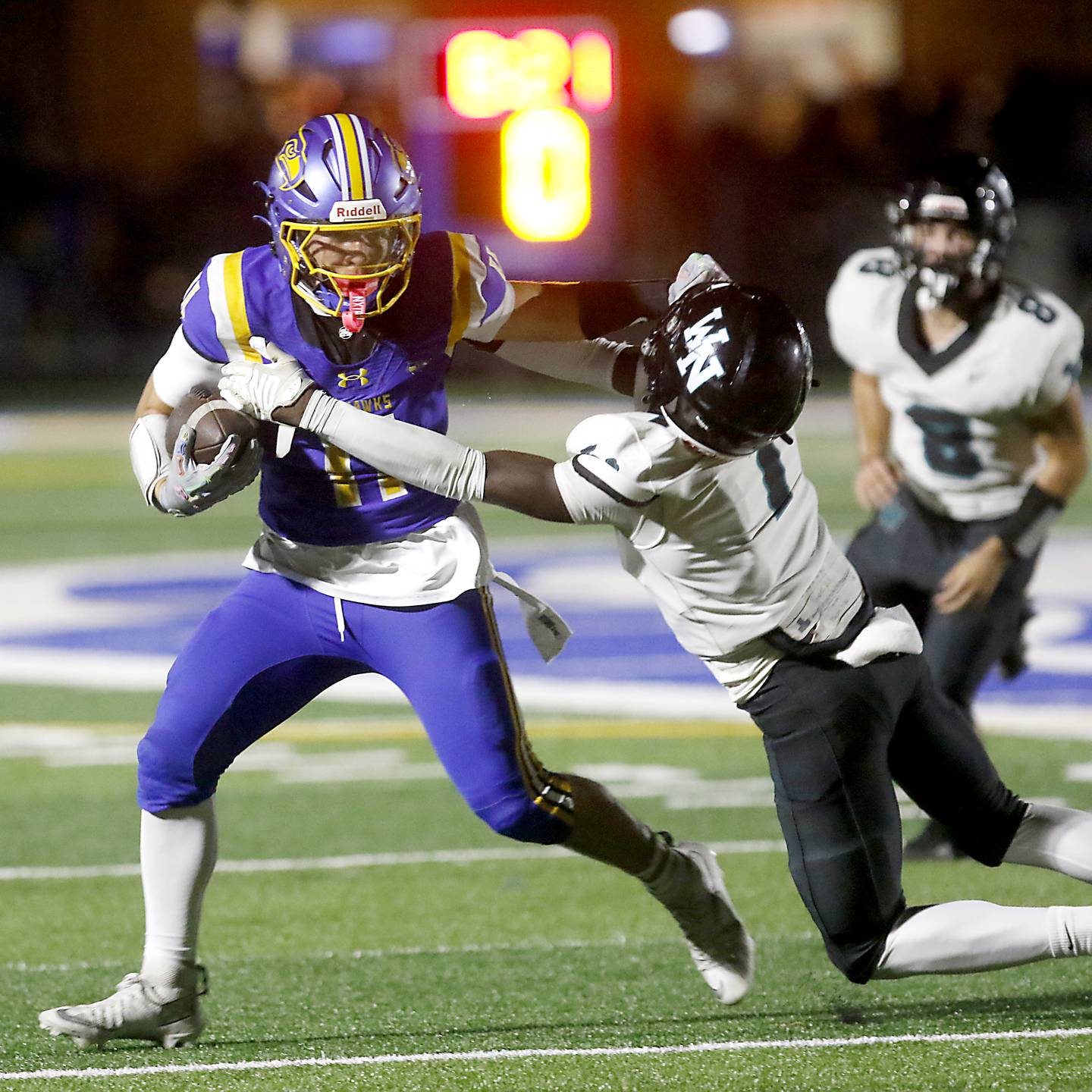 Johnsburg's Ryan Franze stiff arms Woodstock North's JR Fadahunsi as he runs with the ball after a catch during a Kishwaukee River Conference football game on Friday, Sept. 26, 2025, at Johnsburg High School.