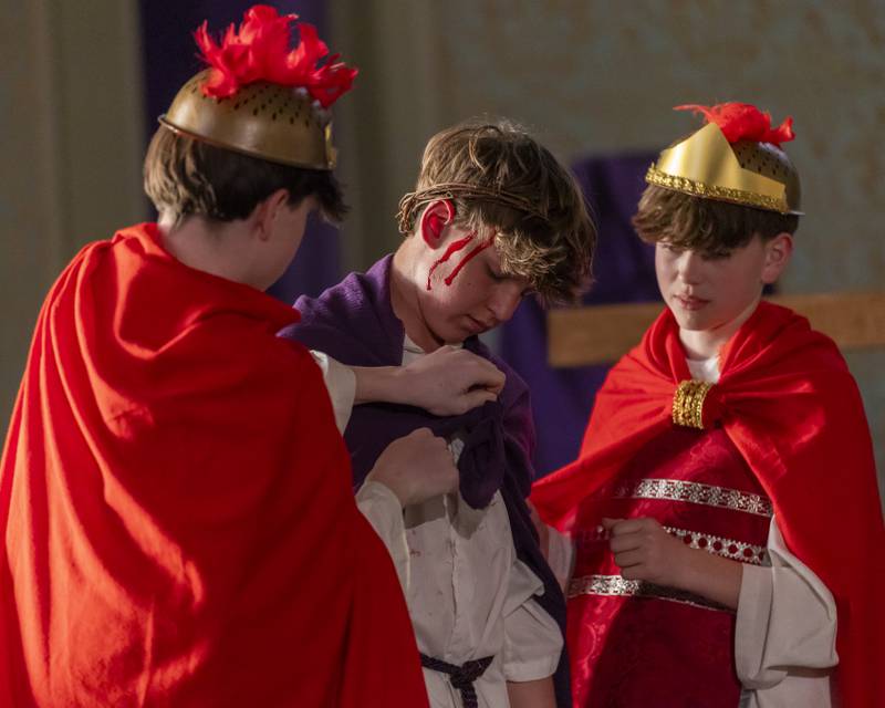Guards take the robes belonging to Jesus, portrayed by Bruno Baker before hanging him on the cross during the Stations of The Cross event on April 16, 2025 at St. Patrick's Church.