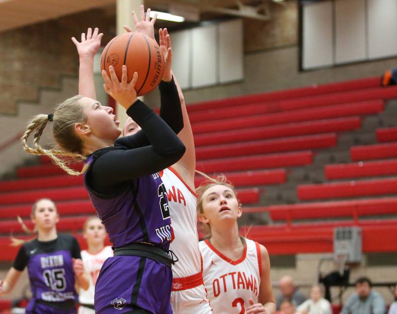 Dixon's Reese Dambman drives to the basket against Ottawa's Skylar Dorsey and teammate Ashlynn Ganiere on Wednesday, Nov. 29, 2023 at Kingman Gym.