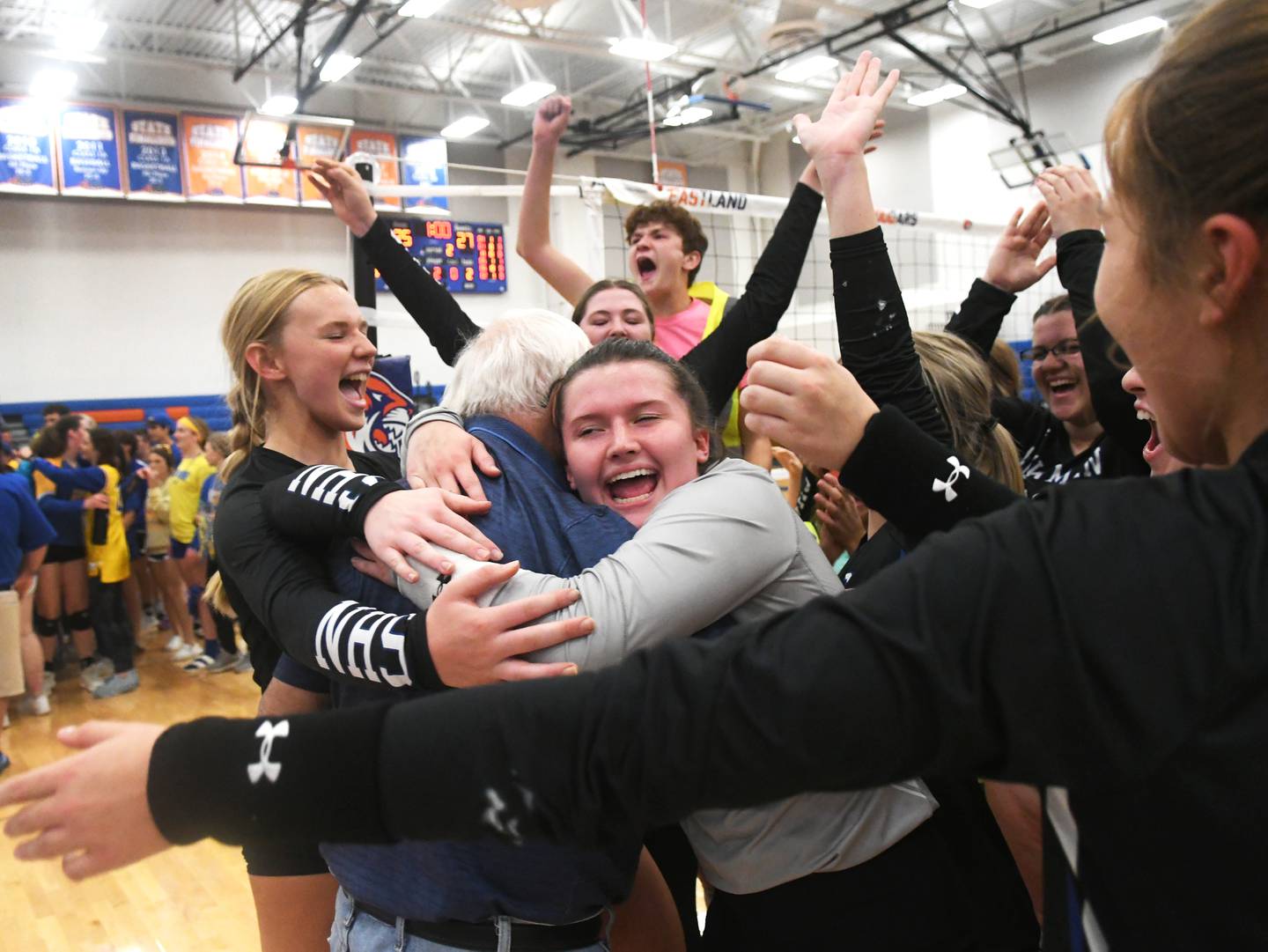 Newman's Addison Foster gets a big hug from a fan as she celebrates with her teammates after winning the 1A Eastland Supersectional in Lanark on Friday, Nov.4.