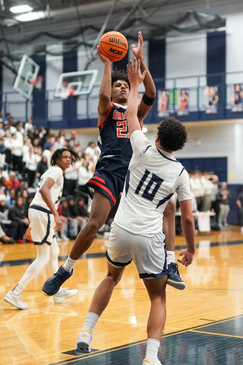 Oswego’s Dasean Patton (23) shoots the ball over Oswego East's Damien Lewandowski (10) during a basketball game at Oswego East High School on Saturday, January 14, 2017.