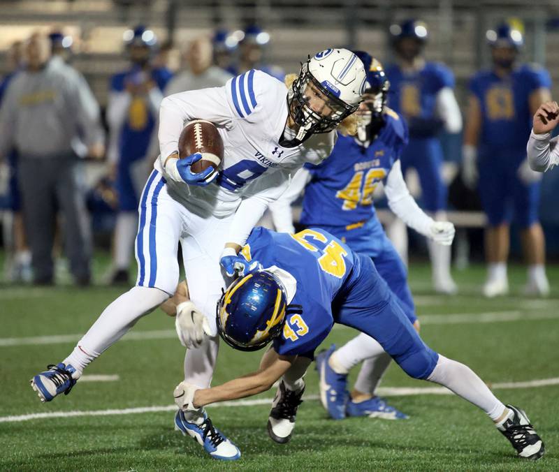 Geneva's Finnegan Weppner (8) is wrapped up by Lake Forest's Miles Specketer (43) during the IHSA Class 6A playoff game Friday November 3, 2023 in Lake Forest.