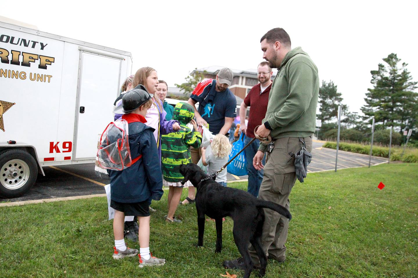 Kane County Sheriff Deputy Matt Schultz and his 8-month-old K-9 in training, Remi, greet children duirng the Kane County Sheriff’s National Night Out in St. Charles on Tuesday, Aug. 6, 2024.