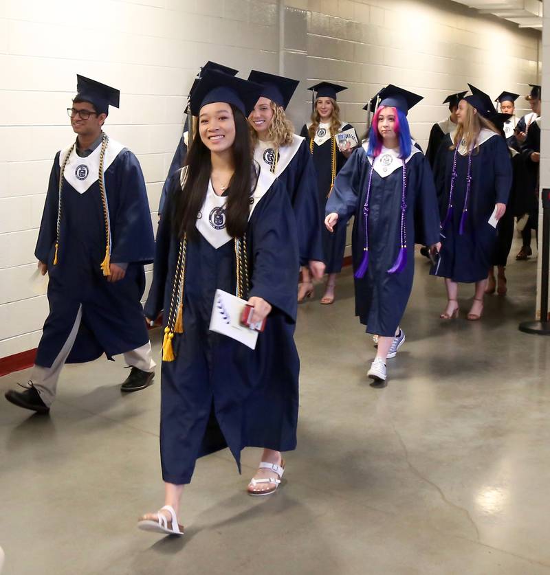 Oswego East High School seniors walk to their graduation ceremony in the NIU Convocation Center in DeKalb on Saturday, May 21, 2022.