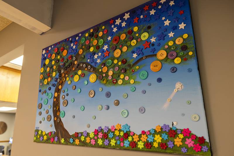 Buttons on a painting seen Wednesday, July 23, 2025, at Shining Star Child Advocacy Center represent the children who were helped by the group in 2022. Each year a new painting is made with buttons the children have picked out.