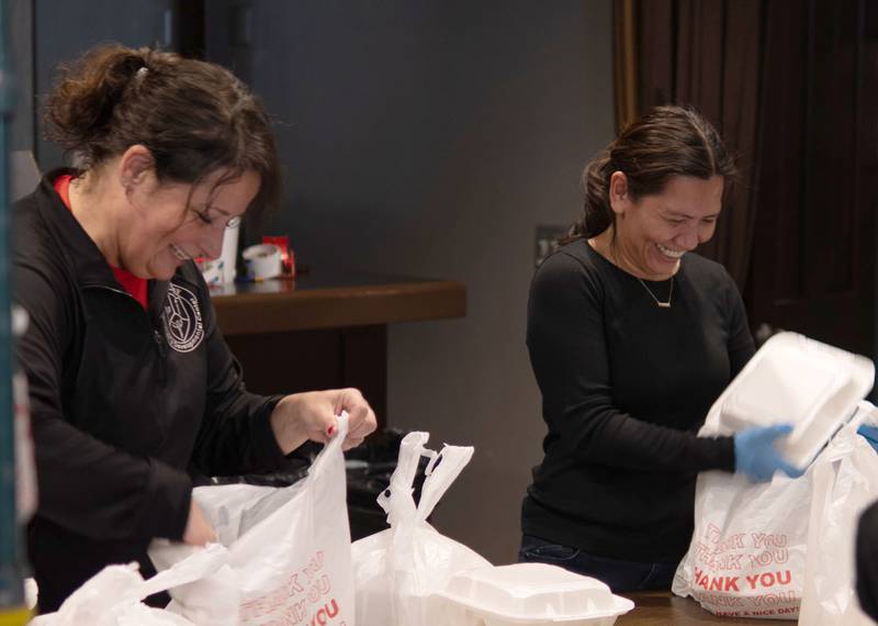 Volunteers help pack dinners to cars during the Lighted Way Spaghetti Supper on Monday, April 22, 2024 at Uptown Bar and Grill in La Salle.