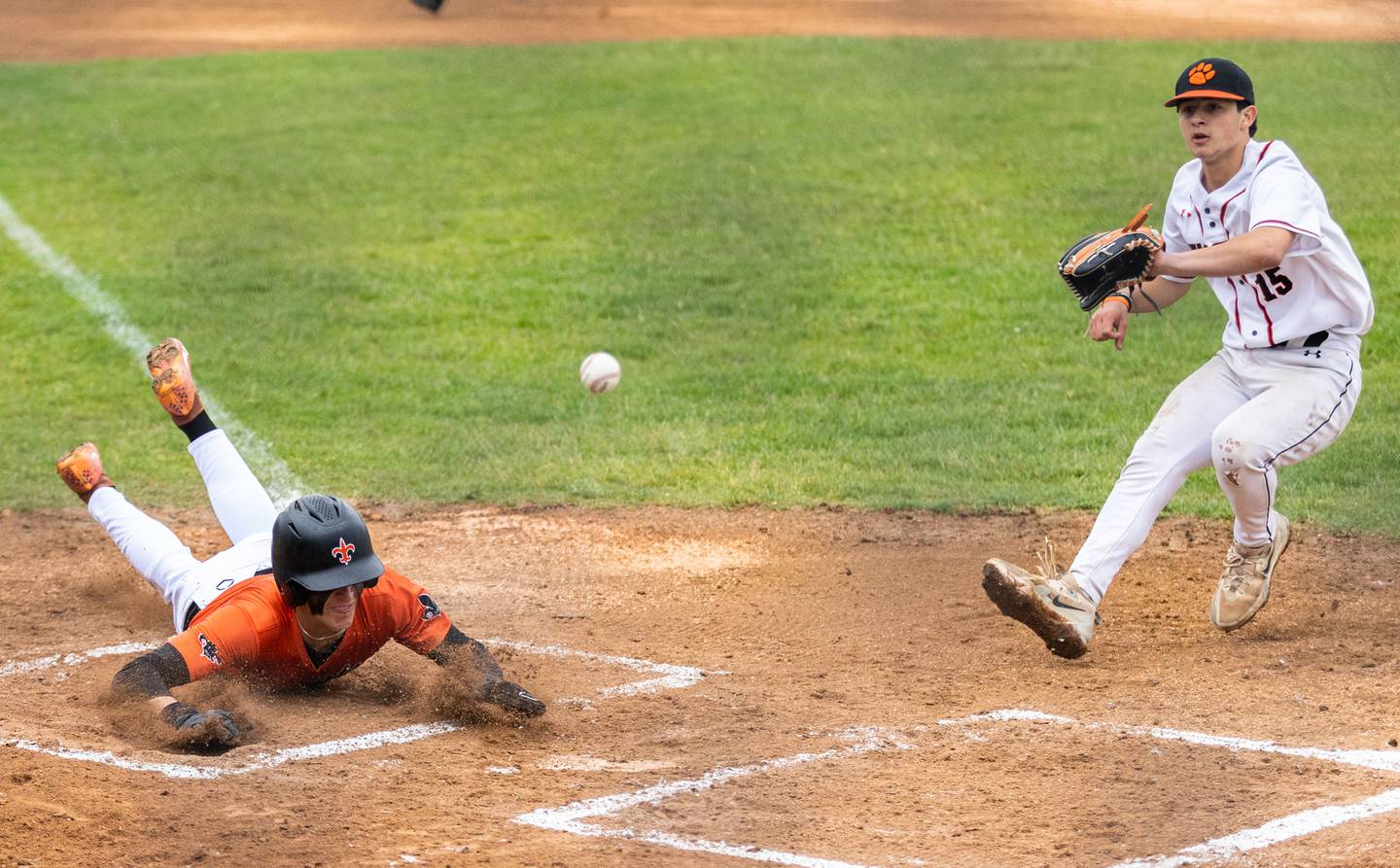 St. Charles East’s James Feigleson slides into home for a run after an error during a game against Wheaton Warrenville South in Wheaton on Wednesday, May 21, 2025.