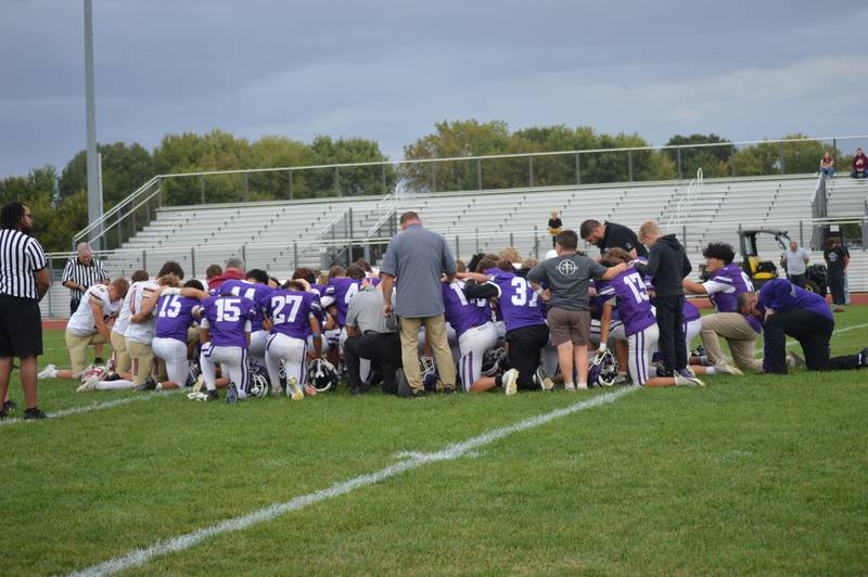 The Rochelle and Morris junior varsity football teams take a knee to pray for Rochelle varsity football player Dylan Manning. Manning suffered a head injury in a game Oct. 3 at Morris and is in recovery from surgery at Loyola Medical Center.
