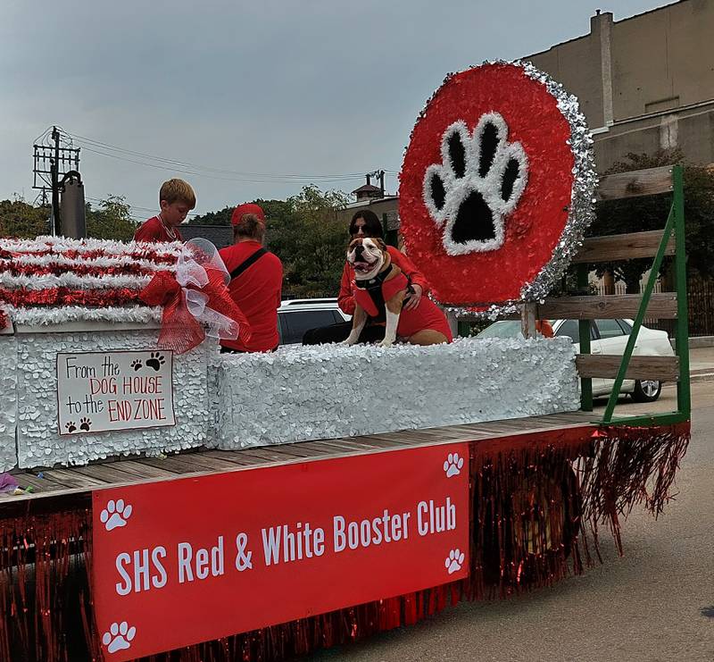 The Streator High School Red and White Booster Club float, featuring a bulldog, moves through the homecoming parade Friday, Sept. 22, 2023, in downtown Streator.