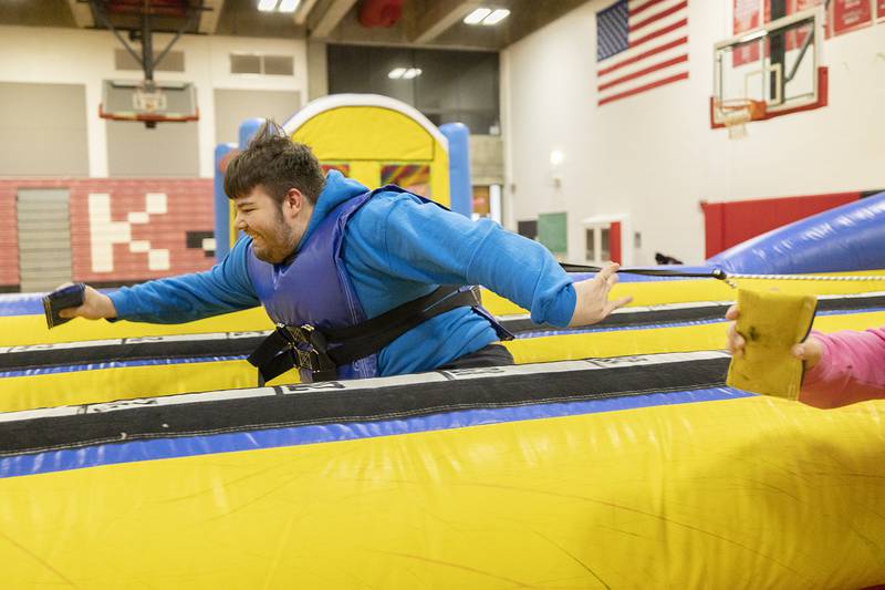 Lyden King of Rock Falls reaches out to plant a velcro marker on the target Wednesday, Feb. 1, 2023 at SaukFest.