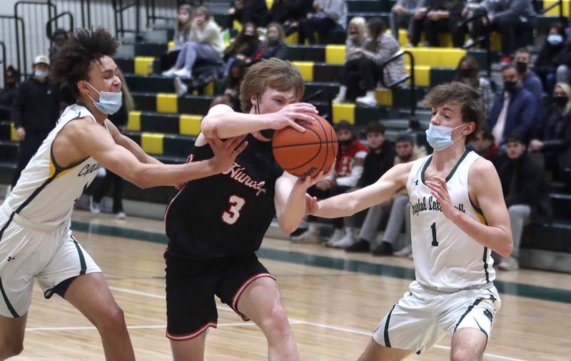 Crystal Lake South’s Isaiah Kirkeeng, left, and Zach Peltz, right, defend against a charging Nathan Ary of Huntley in boys varsity basketball at Crystal Lake Friday night.