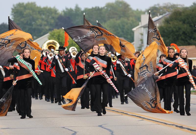 The DeKalb High School flag team and marching band head east on Dresser Road Wednesday, Sept. 27, 2023, leading the way during the homecoming parade.