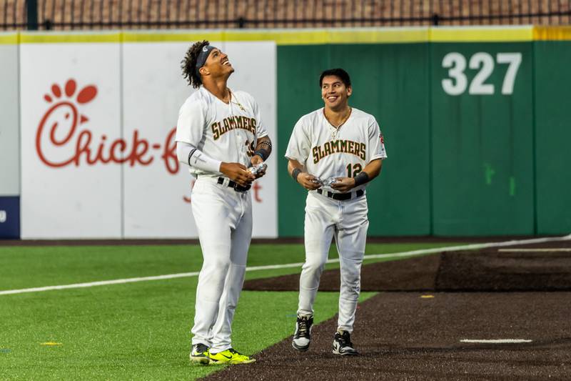 Slammers players Jose Contreras and Antonio Valdez look to the stands before tossing hot dogs to fans following the Wiener Drop World Record Attempt, sponsored by Pabst Light, at Duly Heath and Care Field on July 22, 2025.