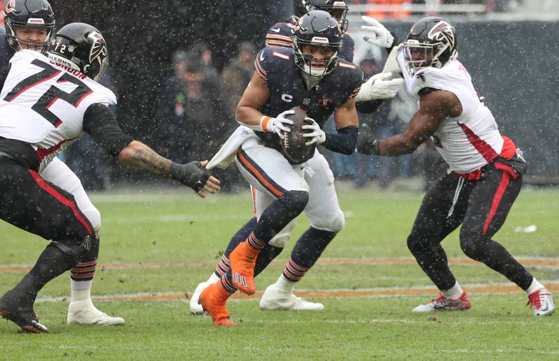 Chicago Bears quarterback Justin Fields splits two Atlanta Falcon defenders during their game Sunday, Dec. 31, 2023, at Soldier Field in Chicago.