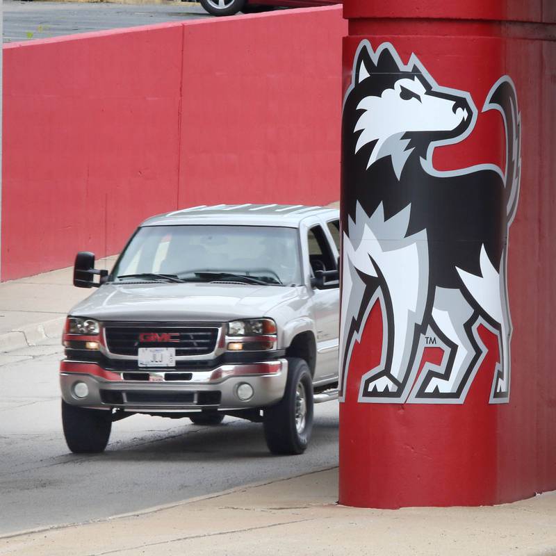 A vehicle drives by part of the new Huskie mural Monday, Aug. 7, 2023, on the Annie Glidden Road railroad underpass, just south of Lincoln Highway in DeKalb. The mural was a joint project between the City of Dekalb and Northern Illinois University.