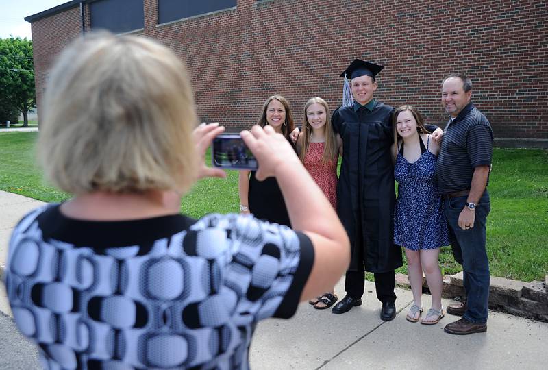Tyler Cunningham poses for a photograph with family members Sunday, May 22, 2022, during the Alden-Hebron High School commencement ceremony in Hebron.