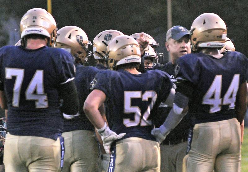 New Marquette Head Football Coach Ken Carlson talks with the team during a timeout Friday against Madison at Marquette.