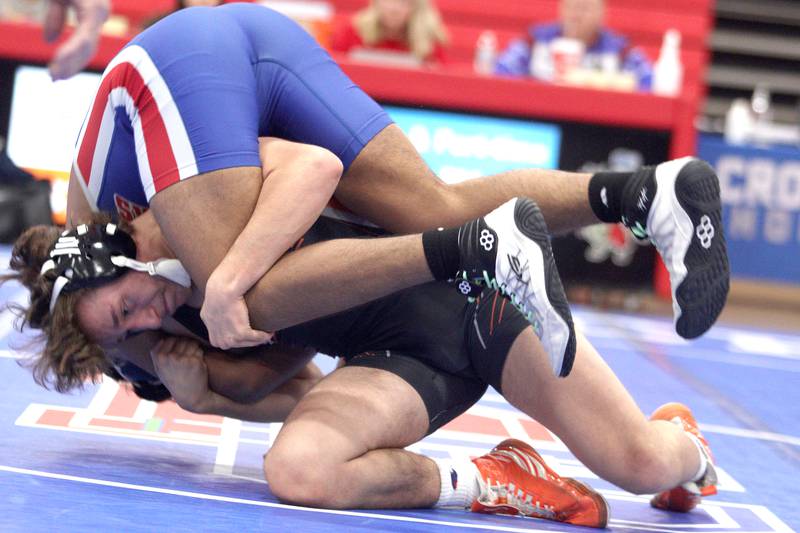 McHenry’s Pedro Jimenez, bottom, battles Dundee-Crown’s Daniel Gutierrez in a 150-pound bout in varsity wrestling at Carpentersville Thursday night.