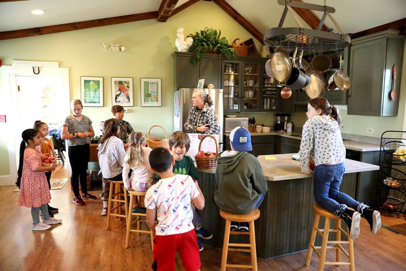 Leslie Meredith, owner of the Farmhouse School, goes over  cooking directions with students from The Learning Door during a Fun Friday at the Farmhouse School in Campton Hills.