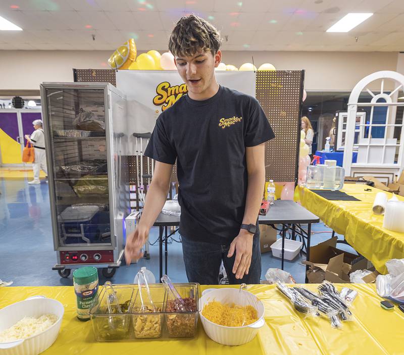 Jonathan Podolski, a Sterling senior, points out the toppings he has available for his Smackin’ Mac macaroni and cheese dish Wednesday, April 29, 2026, at the WACC CEO class trade show.