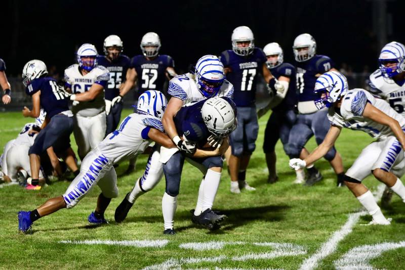 Princeton's Ian Morris gets help from Jace Stuckey on a tackle at Monmouth-Roseville Friday night. The Tigers won 40-0.