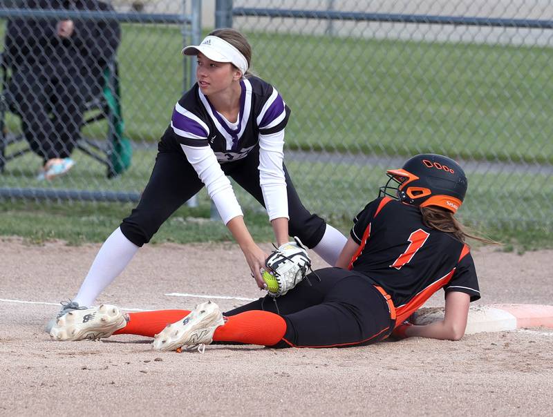 DeKalb's Hazel Montavon dives back in safely to first as Dixon’s Kennedy Haenitsch applies the tag Thursday, May 22, 2025, during their game at DeKalb High School.
