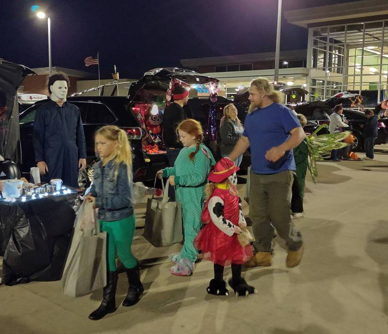Trick-or-treaters go car to car to collect candy during Wednesday night's trunk or treat event at John F. Kennedy Elementary School in Spring Valley.