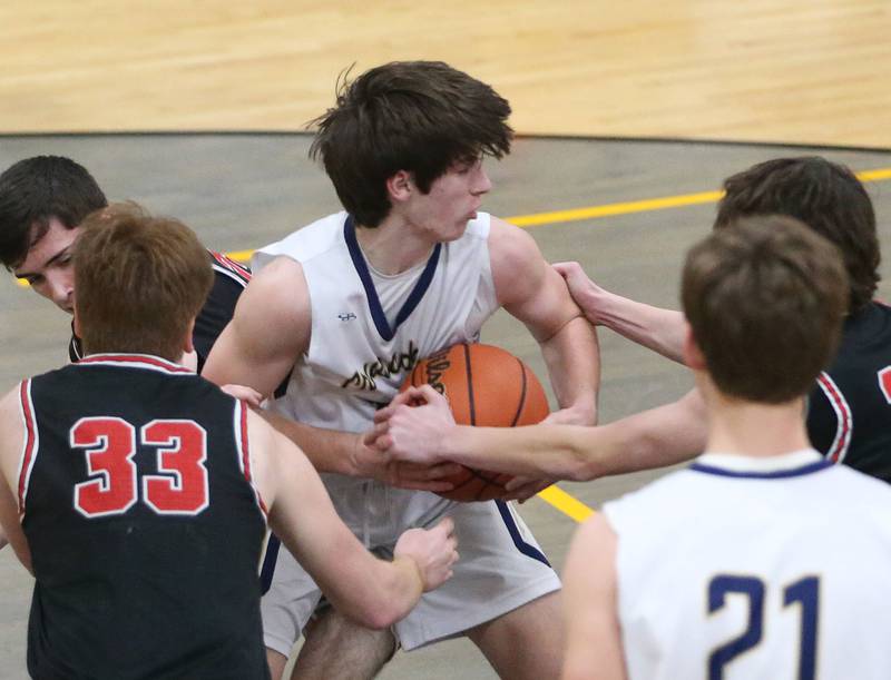 Marquette's Alec Novotney grabs a loose ball over Woodland's Kenny Eutsey during the Tri-County Conference Tournament on Thursday, Jan. 25, 2024 at Putnam County High School.