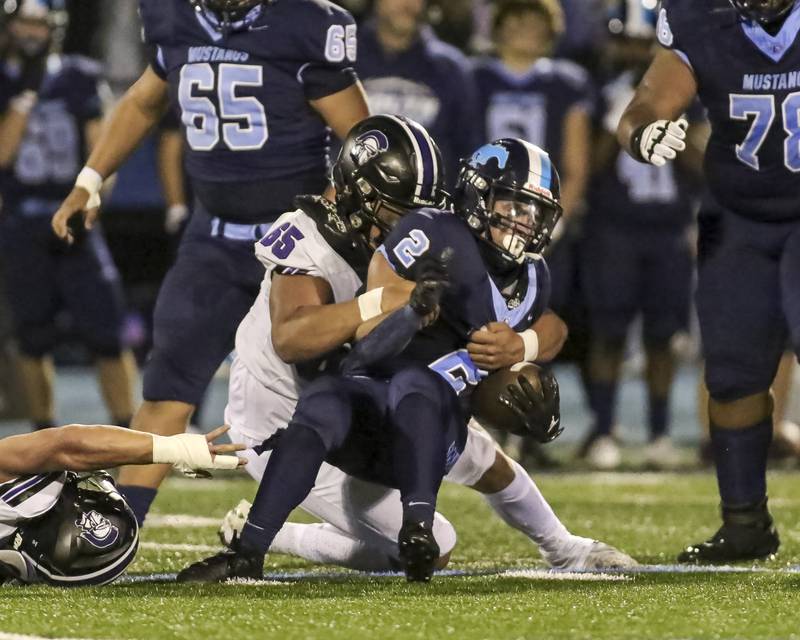 Downers Grove North's Aiden Solecki (65) brings down Downers Grove South's Joseph Vieyra (2) during football game between Downers Grove North at Downers Grove South Friday, Sept 5, 2025  in Downers Grove.