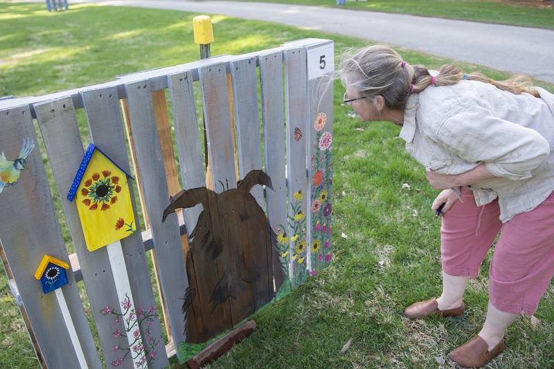 Camper takes a close look at one of the works Thursday, April 21, 2022 in Lowell Park.