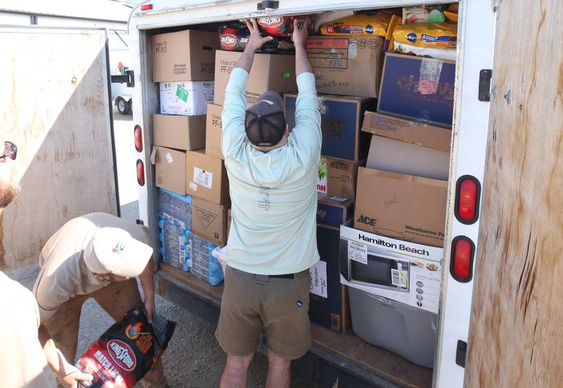 Elemore Electric employees Dan Elmore and Nolan Drake, load hundreds of supplies into a trailer that will be sent to areas effected by Hurricane Helene on Friday, Oct. 4, 2024 at their shop in Dover.