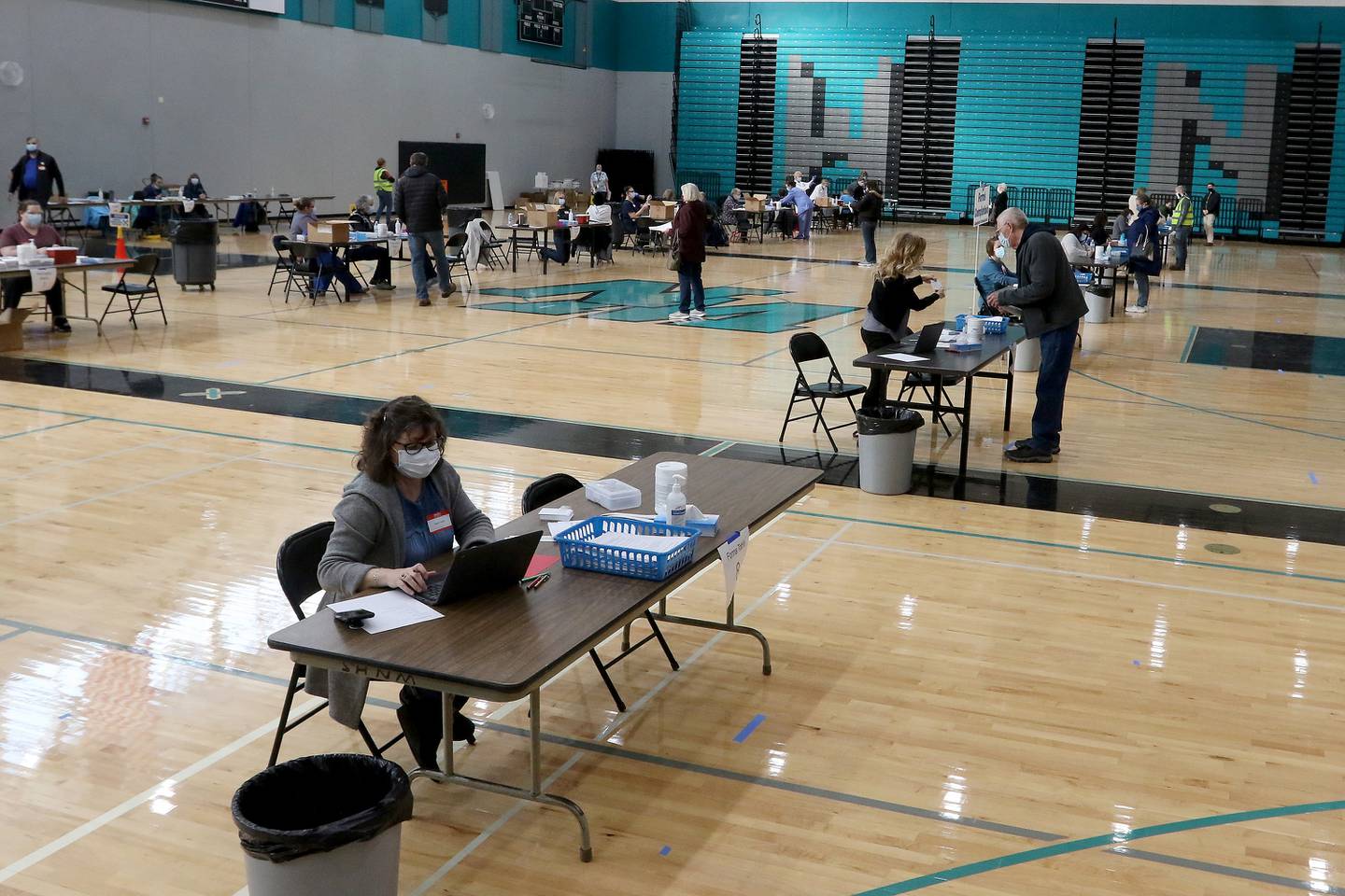 Various stations for checking in and vaccine administration are spaced throughout the Woodstock North High School gymnasium during a vaccination clinic on Thursday, Feb. 11, 2021 in Woodstock.  The clinic is hoping to vaccinate 2,600 employees of school districts in the northern half of McHenry County with the Moderna COVID-19 vaccine over the course of Thursday and Friday.