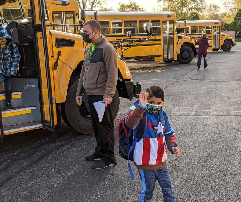 Students, with physical education. teacher Andrew Goron, arrive for school at Troy Shorewood Elementary School during the fall of 2020.