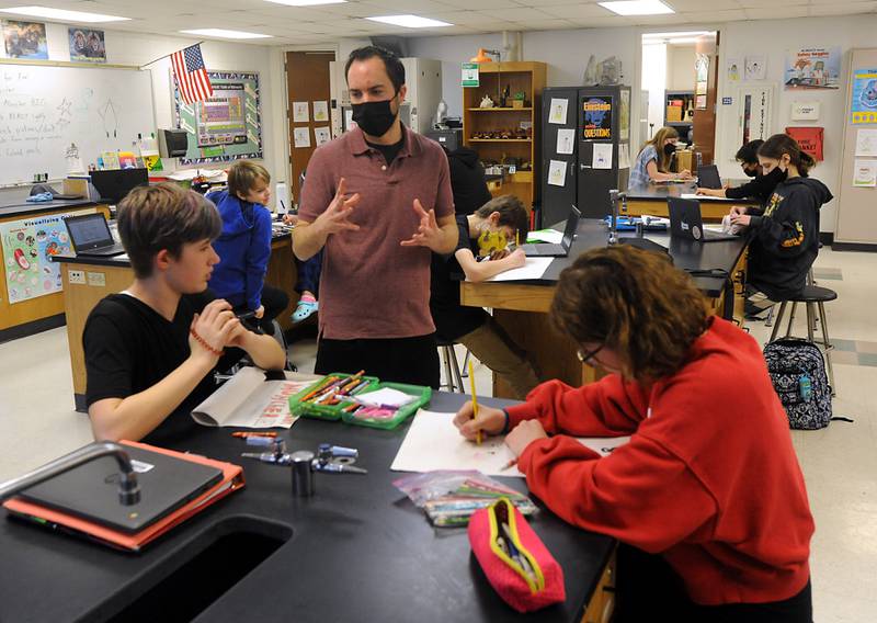 Science teacher Brian Sanford talks with students Tuesday, March 22, 2022, as he teaches seventh-grade science at Algonquin Middle School. Sanford, who bring art and games into the classroom to help teach science, has asked the students to draw monster movie posters as part of the current science study unit.
