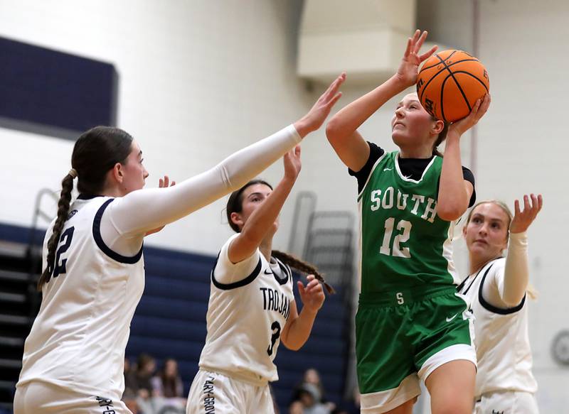 Crystal Lake South's Gaby Dzik shoots the ball between the defense of Cary-Grove's Olivia Leuze, (left) Kennedy Manning (center) and Malaina Kurth (right) during a Fox Valley Conference girls basketball game on Tuesday, Dec. 2, 2025, at Cary-Grove High School in Cary.