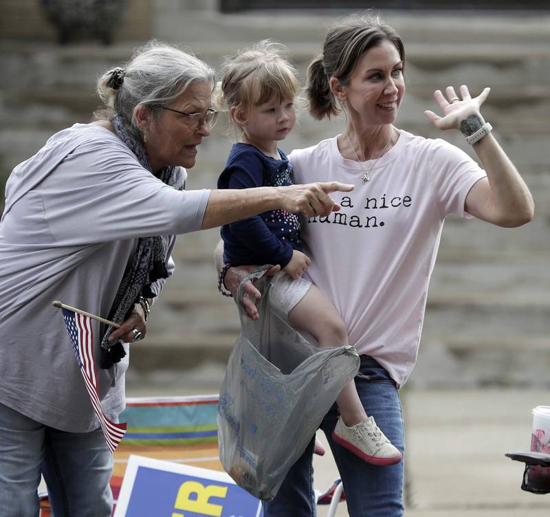 Sue Malmbrog, of Elburn, from left, waves to the passing floats with Kennedy, 2, and her mom Niki Gabor, both of Aurora during the Elburn Days parade Friday August 19, 2022 in Elburn.