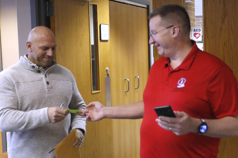 Andy Davis receives a ticket to show he was in line at 8 a.m. from McHenry Deputy Clerk Monte Johnson as he files his paperwork Tuesday, Nov. 12, 2024, to run for another term as Ward 5 alderman during first day of filing for the Consolidated Election on April 1, 2025. If more than one candidate is in line at 8 a.m. for a single race, a lottery is held to determine whose name goes first on the ballot.