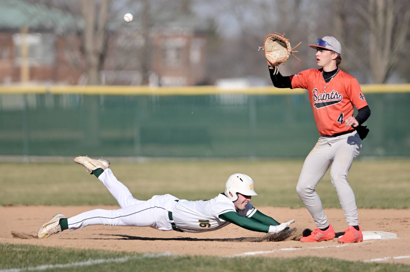 Waubonsie Valley’s Jack Roberts dives safely back to first as St. Charles East’s Dylan McCabe takes the throw in a baseball game in Aurora on Monday, Mar. 23, 2026.