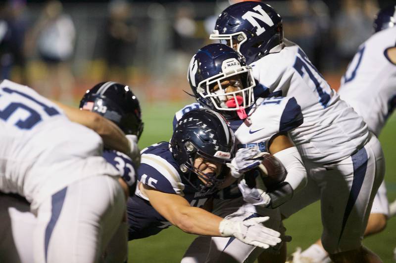 Nazareth's Eddie McClain is tackled by IC Catholic's Foley Calcagno on Friday, Sept.15,2023 in Elmhurst.