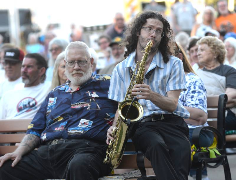 Jonny Lyons and the Pride saxophonist Maxwell Meador sits with Ed Chodl of Mt. Morris while he plays a song at the Mt Morris Jamboree on Friday, June 27, 2025.
