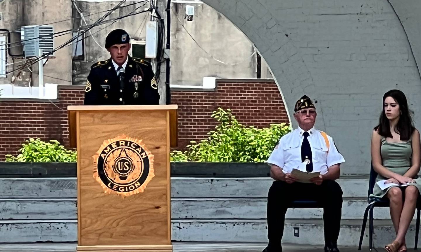 Staff Sgt. Luke Moritz reads a poem to honor fallen warriors on Monday at Grandon Civic Center in Sterling.  Joining Moritz on the Dias were Michael Wolber and Janice Francis.