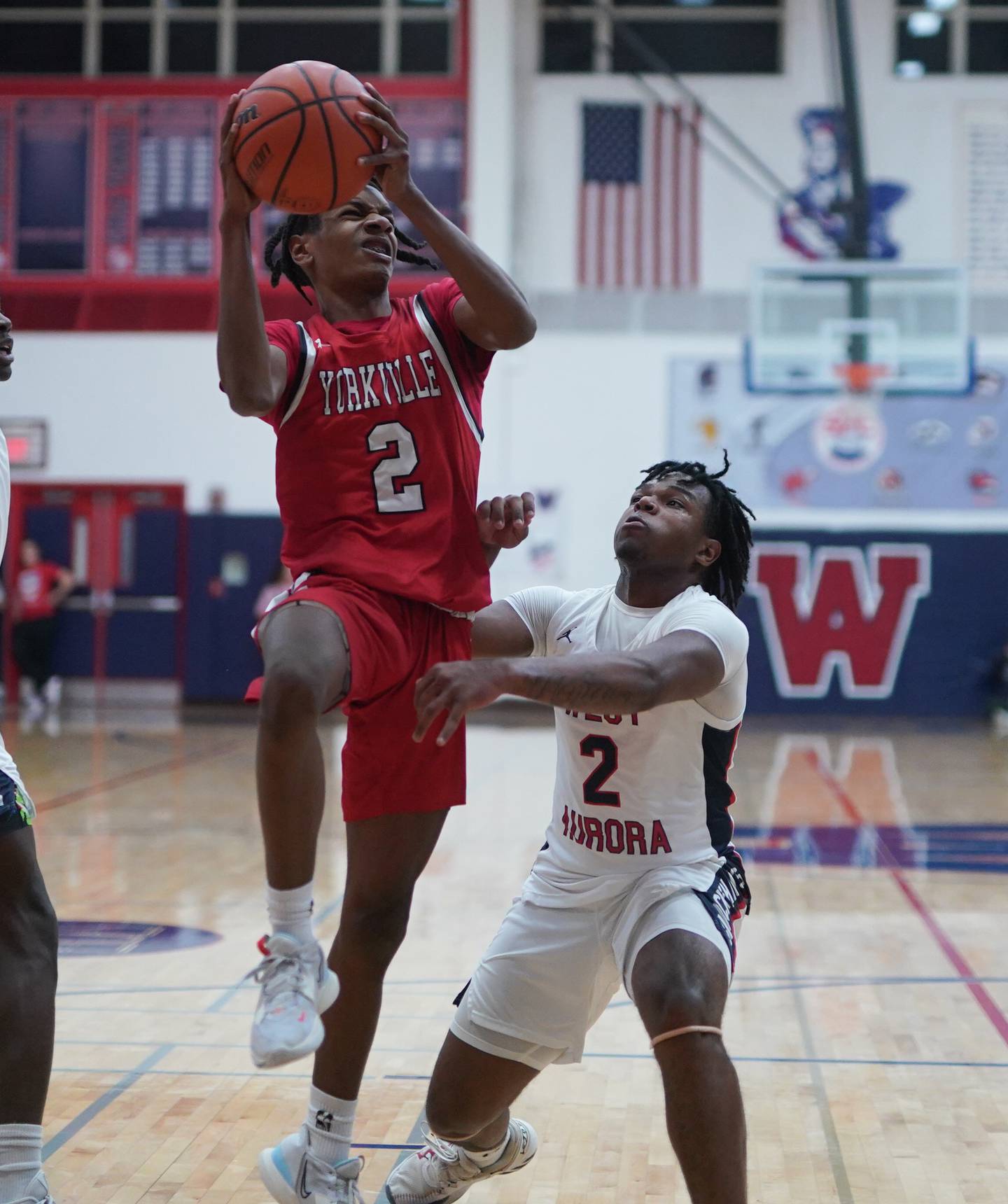 Yorkville's Michael Dunn (left) drives to the hoop against West Aurora's Calvin Savage during a basketball game at West Aurora High School on Tuesday, Nov 28, 2023.
