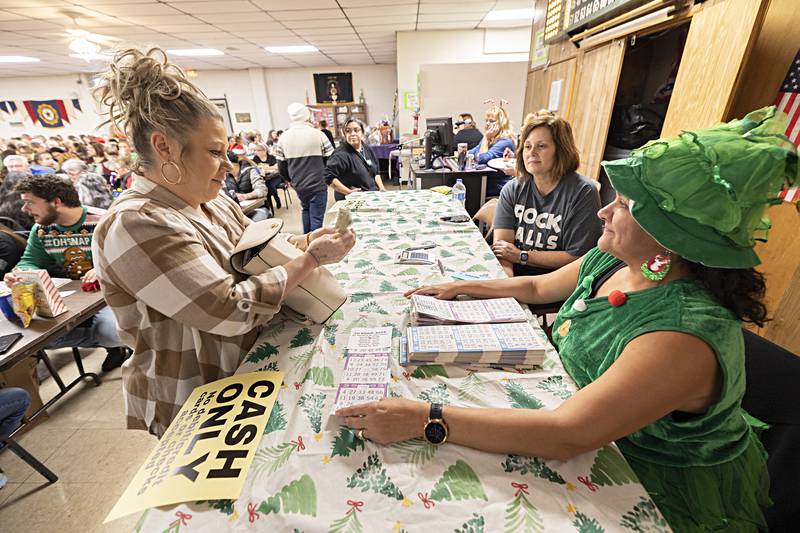Kelly Bruder (left) buys BINGO tickets from Julie Jacobs Thursday, Nov. 16, 2023 during the Hometown Holiday’s BINGO event in Rock Falls. The weekend holiday fun kicked off with a jam packed round of BINGO.