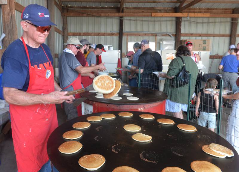 Dale Meyers of the Ogle County Pilots flips two pancakes during the association's Fly-In Drive-In Breakfast on Tuesday held in conjunction wit the Let Freedom Ring festival. More than 1,000 breakfasts were served at the Ogle County Airport.