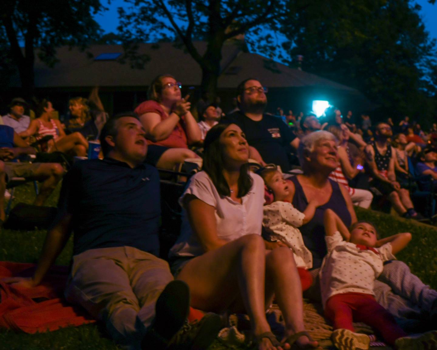 Husband and wife Wesley and  Kara Budd along with 1 year old Gwyneth and 5 year old Eleanor Bubb relax on their grandmother, mother of Kara, Anita Zurbrugg who all were residents at one point watch the fireworks July 4th at Hopkins park in DeKalb.