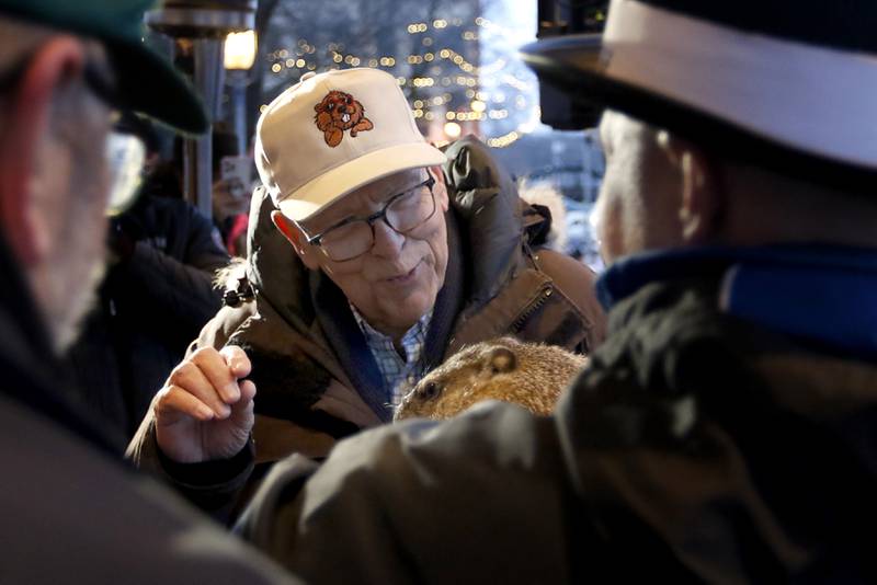 WGN-TV chief meteorologist Tom Skilling talks with Woodstock Willie in  “Groundhogese” to see if Willie saw his shadow while being held by handler Mark Szafran on Friday, Feb. 2, 2024, during the annual Groundhog Day Prognostication on the Woodstock Square.